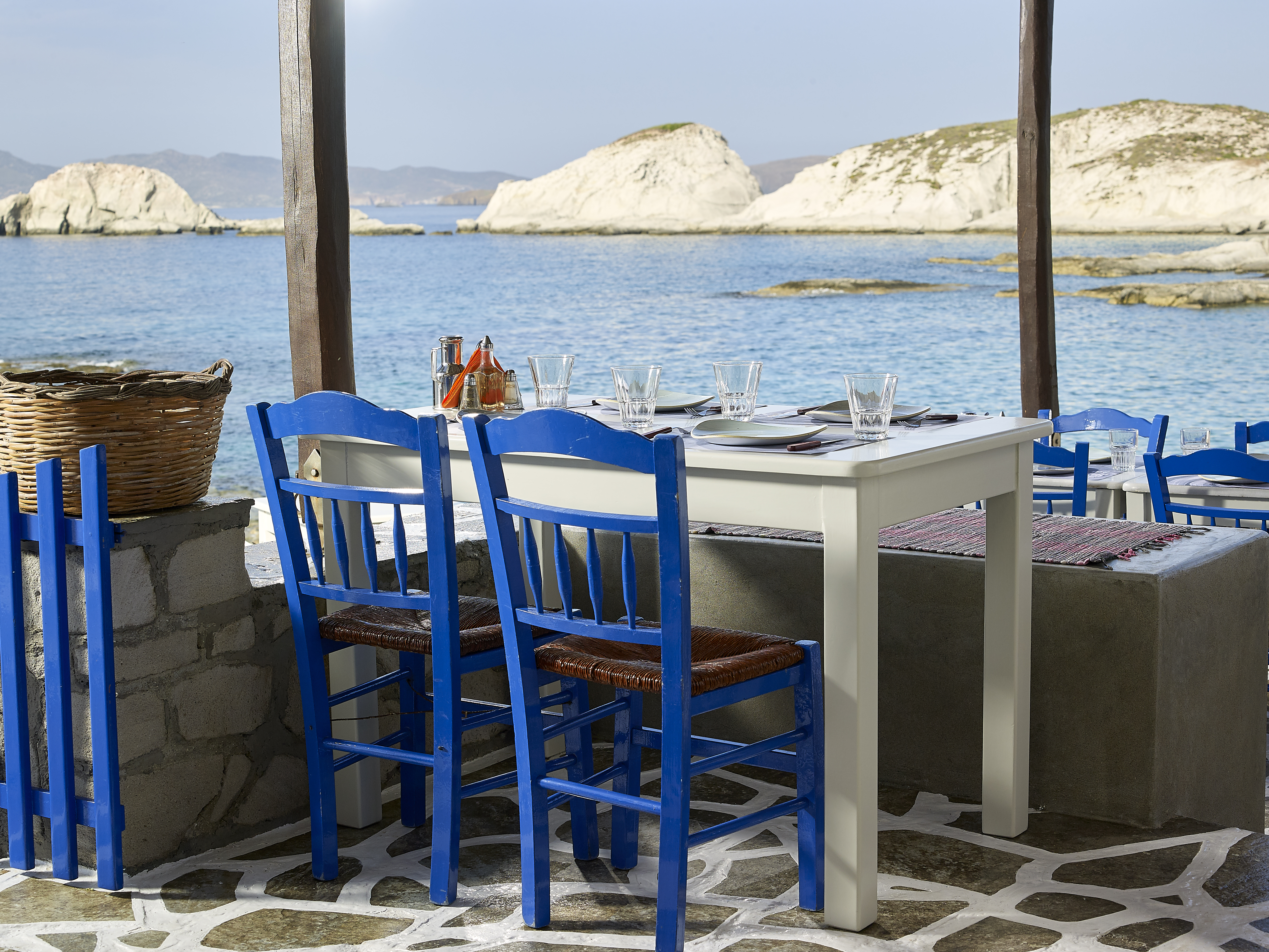 Sea view landscape table chairs cycladic decoration aegean colours blue horizon summer Medusa restaurant Milos island Greece